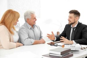 A person arranging rings, watches, and necklaces on a velvet-lined jewelry tray at home.