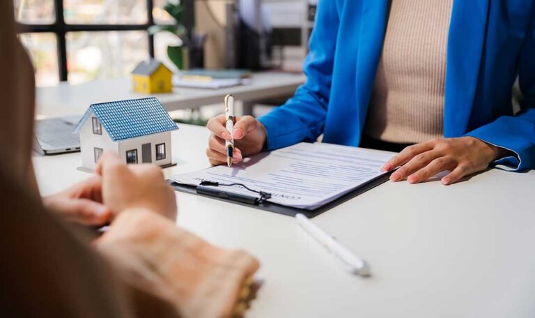 A resident reviews an insurance declaration page beside a folder of policy documents and household records.